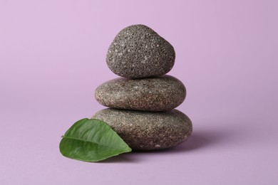 Photo of Stack of rocks on lilac background. Harmony and life balance