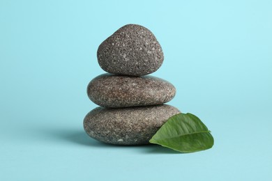 Photo of Stack of rocks on light blue background. Harmony and life balance