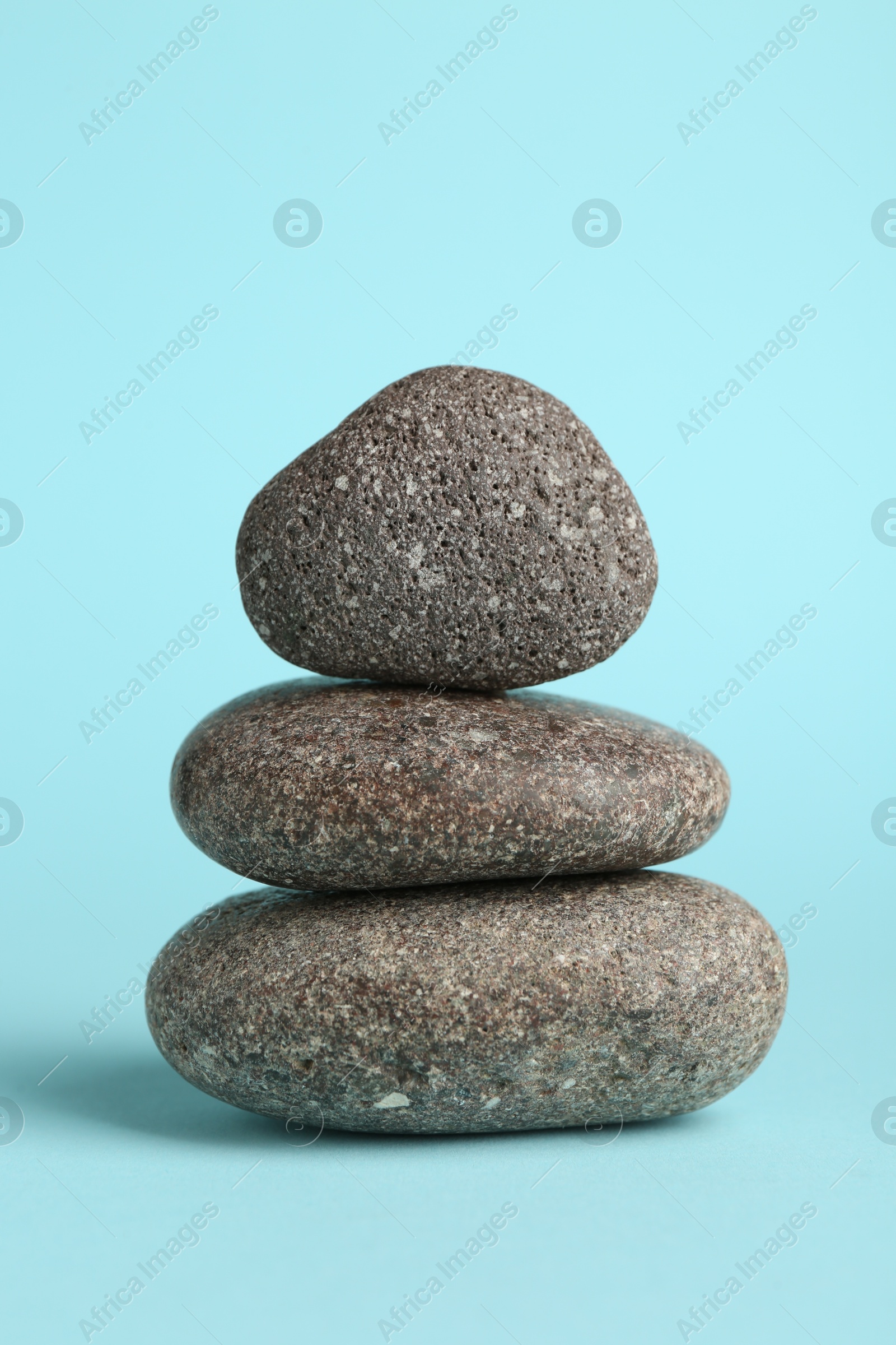 Photo of Stack of rocks on light blue background. Harmony and life balance