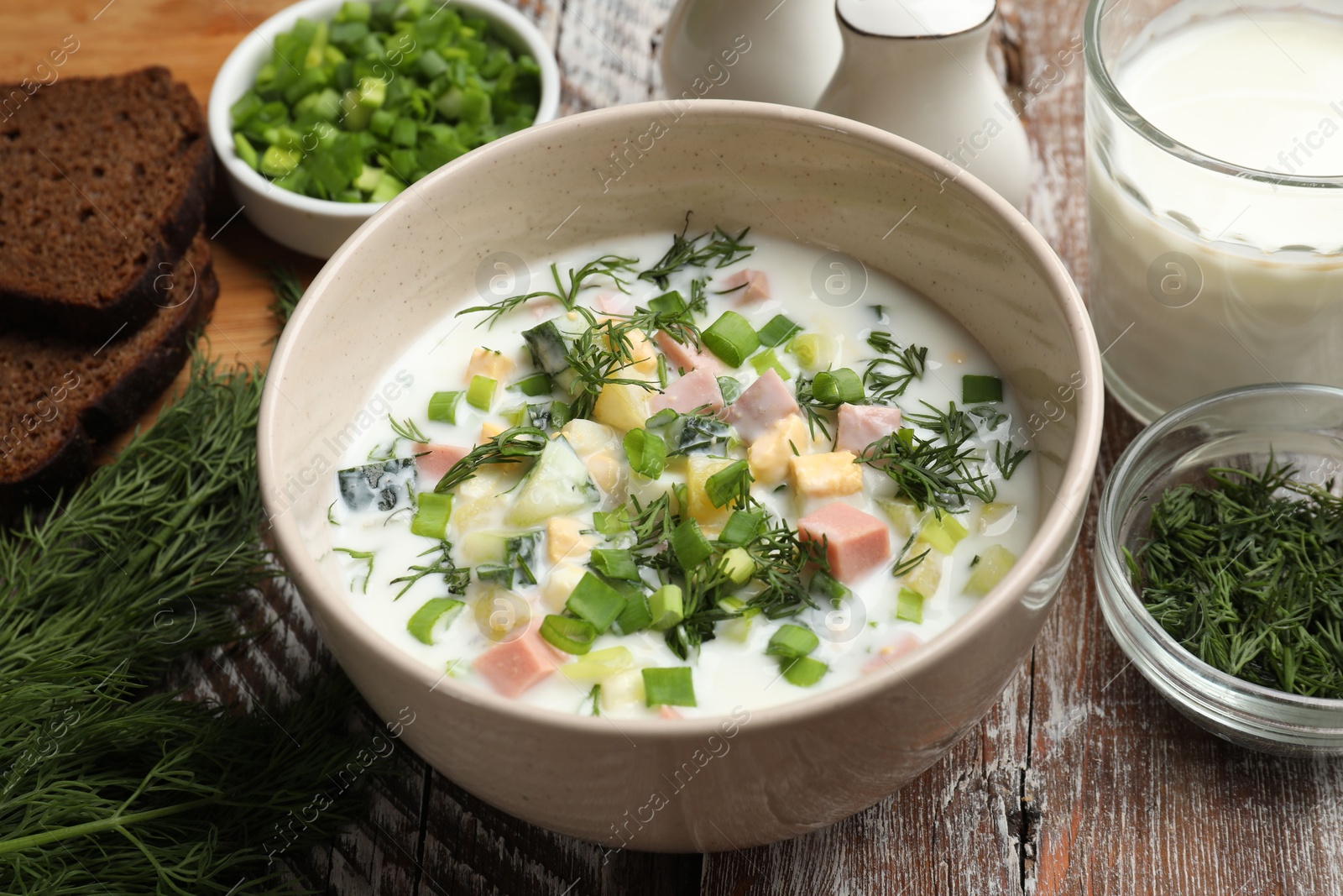 Photo of Delicious okroshka soup in bowl on wooden table, closeup