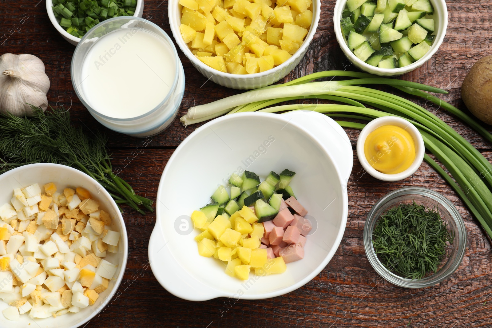 Photo of Ingredients for okroshka soup on wooden table, flat lay