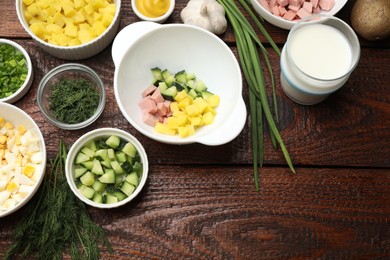 Photo of Ingredients for okroshka soup on wooden table, flat lay. Space for text