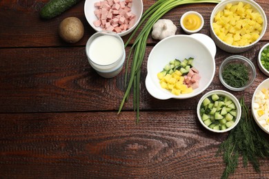 Photo of Ingredients for okroshka soup on wooden table, flat lay. Space for text