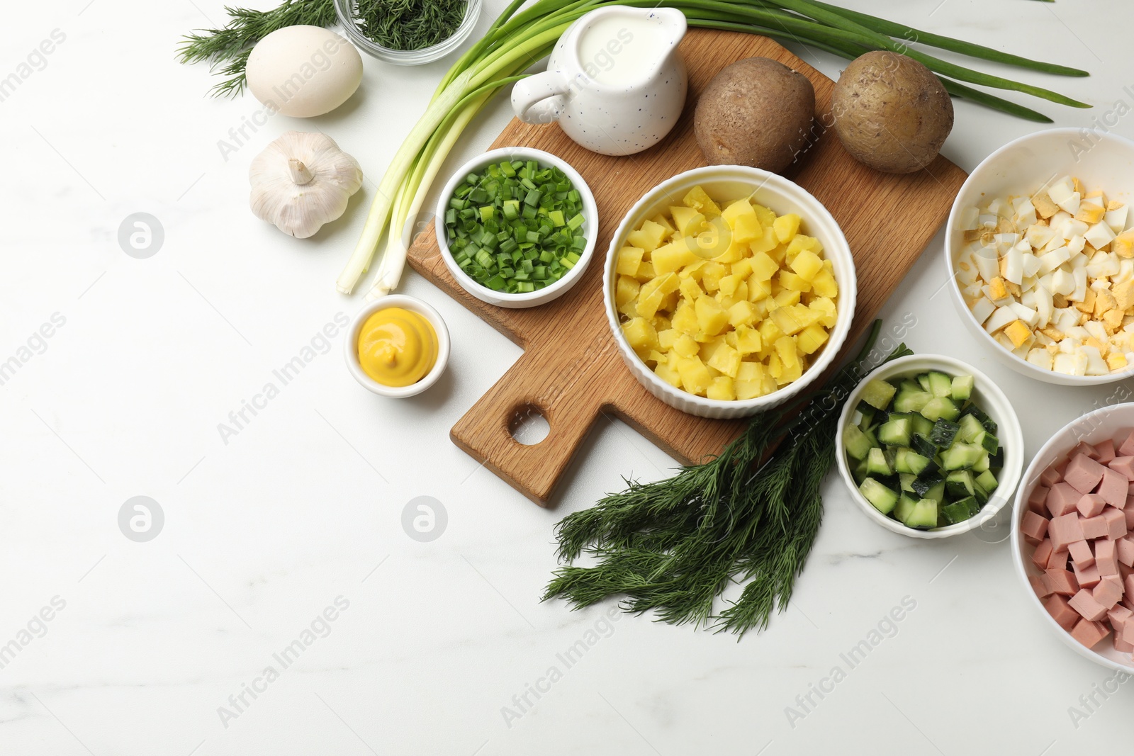 Photo of Ingredients for okroshka soup on white marble table, flat lay. Space for text