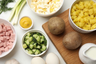 Photo of Ingredients for okroshka soup on white table, flat lay