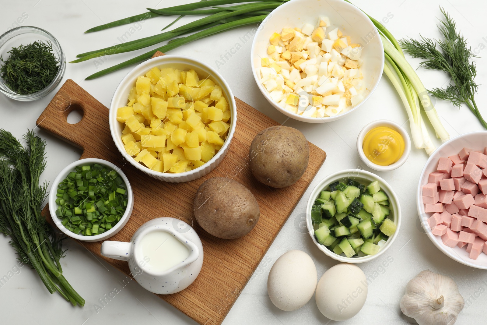 Photo of Ingredients for okroshka soup on white table, flat lay