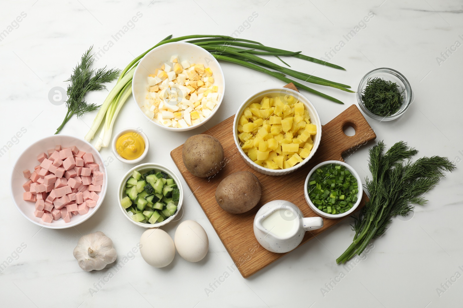 Photo of Ingredients for okroshka soup on white marble table, flat lay