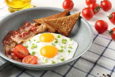 Photo of Tasty fried eggs with bacon and toasts served on table, closeup