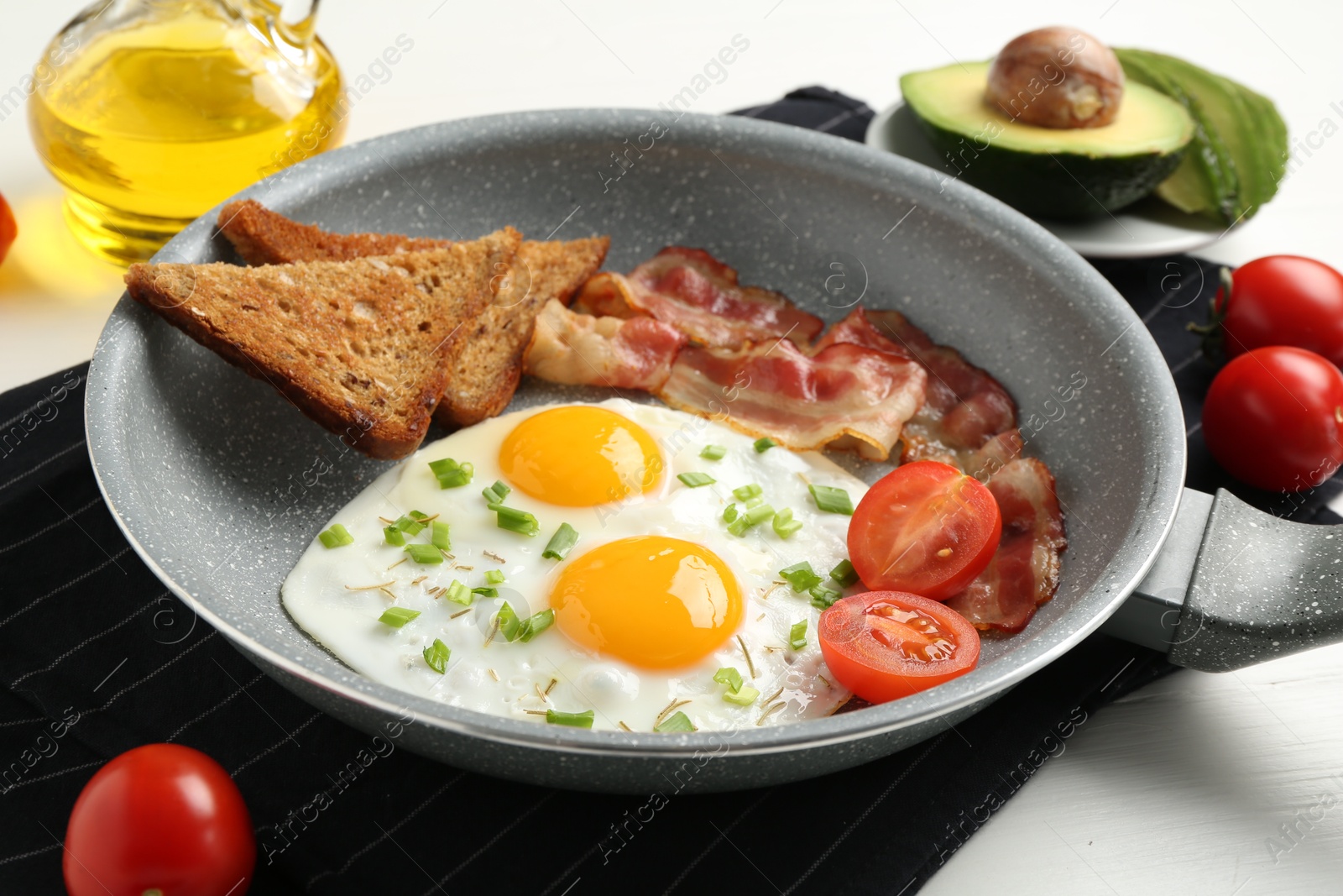 Photo of Tasty fried eggs with bacon and toasts served on white wooden table, closeup