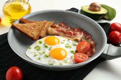 Photo of Tasty fried eggs with bacon and toasts served on white wooden table, closeup