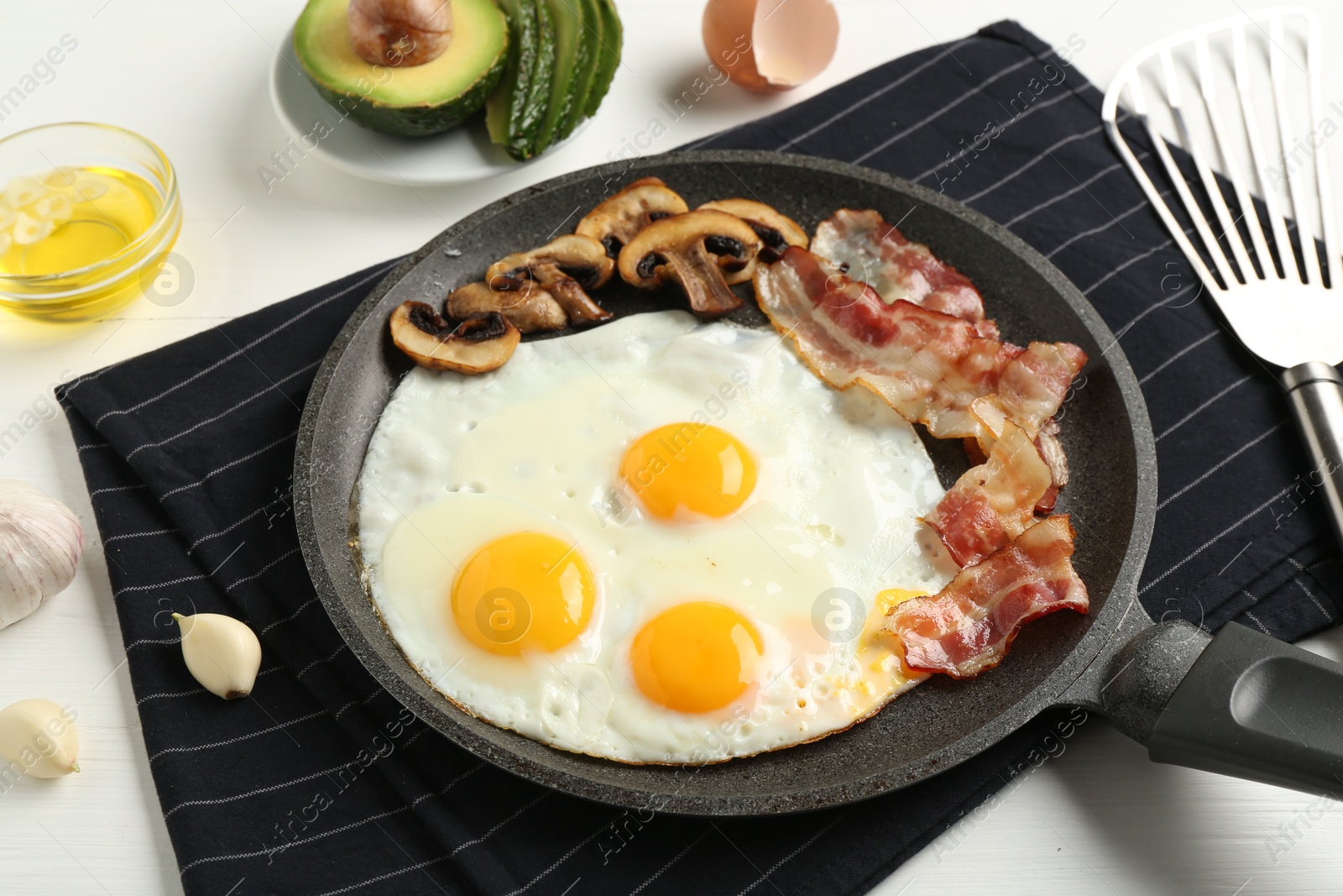 Photo of Tasty fried eggs with bacon and mushrooms served on white wooden table, closeup