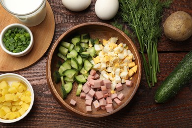 Photo of Different ingredients for okroshka soup on wooden table, flat lay