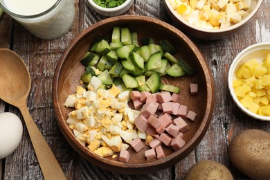 Photo of Different ingredients for okroshka soup on wooden table, flat lay