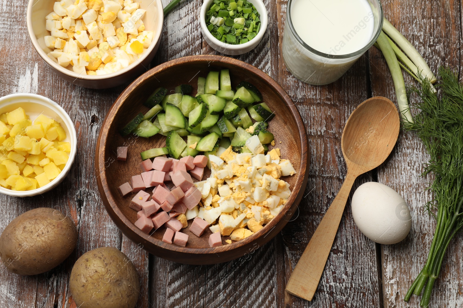 Photo of Different ingredients for okroshka soup on wooden table, flat lay