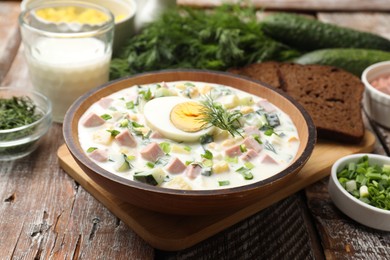 Photo of Delicious okroshka soup with kefir served on wooden table, closeup