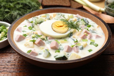 Photo of Delicious okroshka soup with kefir served on wooden table, closeup