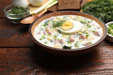 Photo of Delicious okroshka soup with kefir served on wooden table, closeup