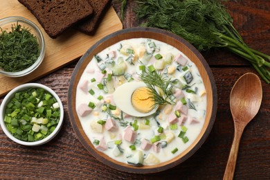 Photo of Delicious okroshka soup with kefir served on wooden table, flat lay