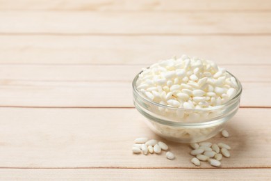 Photo of Puffed rice in bowl on white wooden table, closeup. Space for text