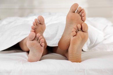 Photo of Couple lying in bed with white sheets, closeup