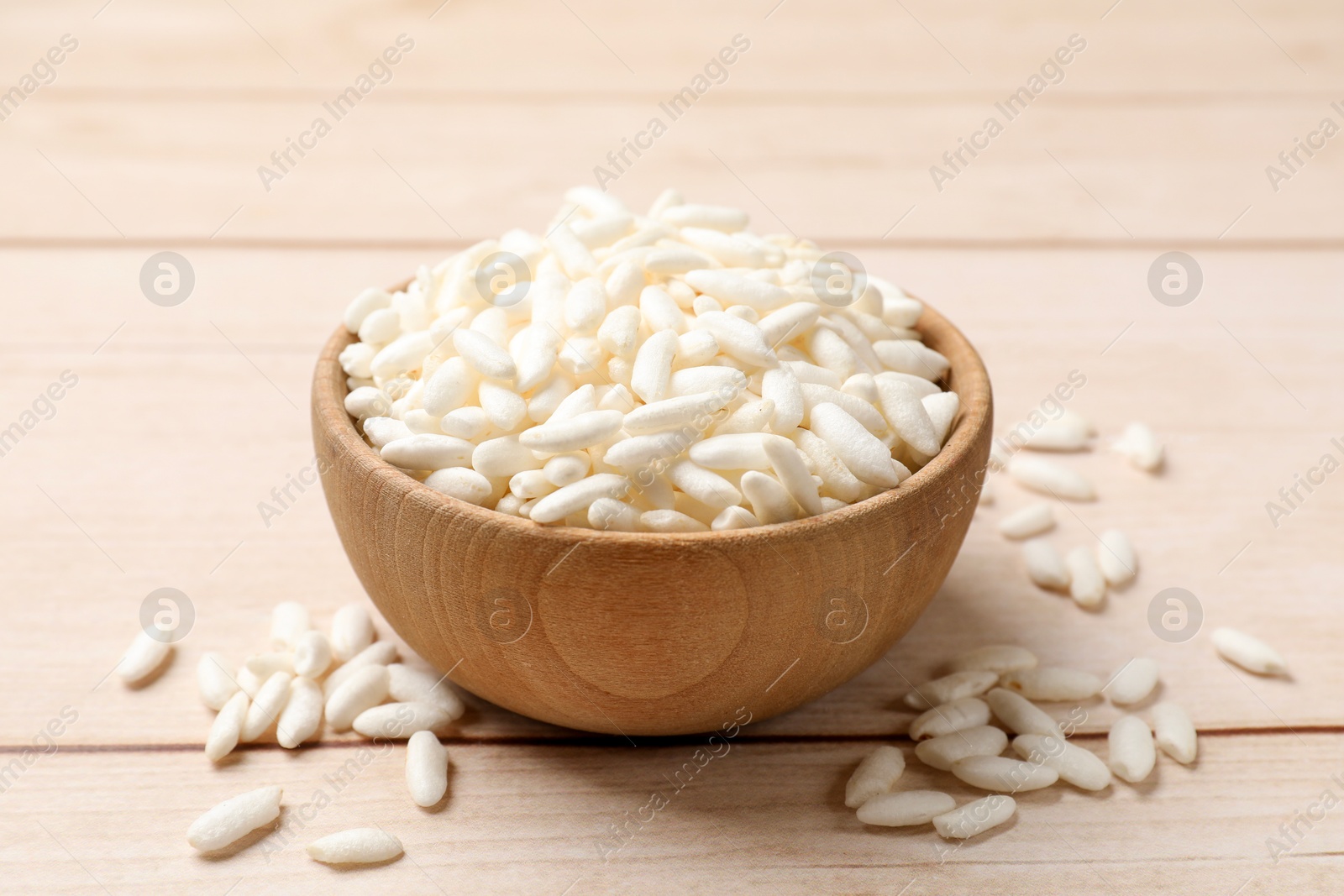 Photo of Puffed rice in bowl on wooden table, closeup