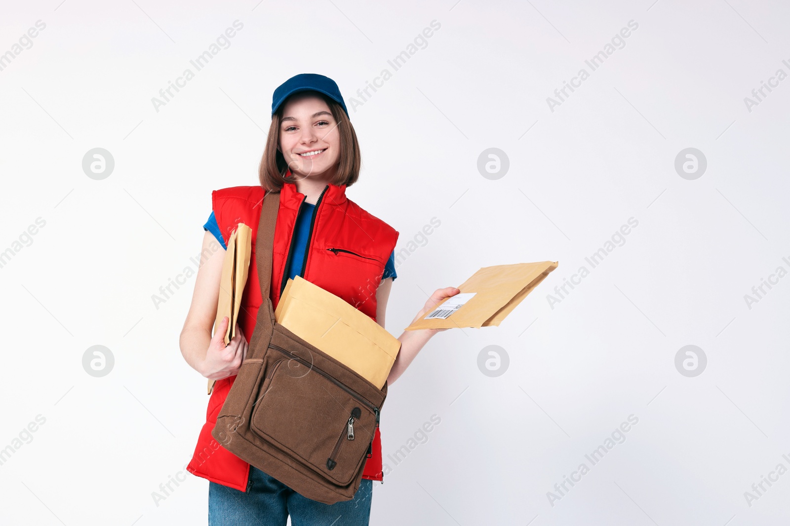 Photo of Happy postwoman with bag and envelopes on white background. Space for text