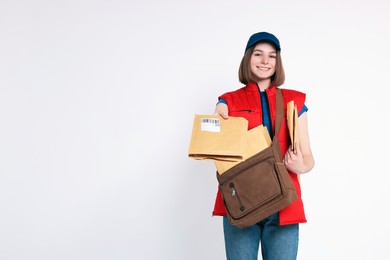 Photo of Happy postwoman with bag giving envelopes on white background. Space for text