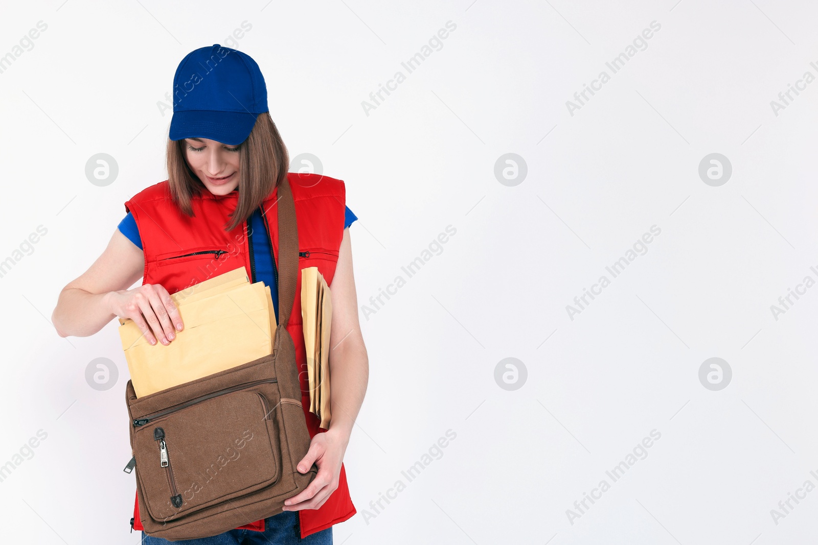 Photo of Happy postwoman with bag and envelopes on white background