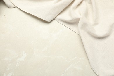 Photo of Beige tablecloth on light gray textured background, top view. Space for text