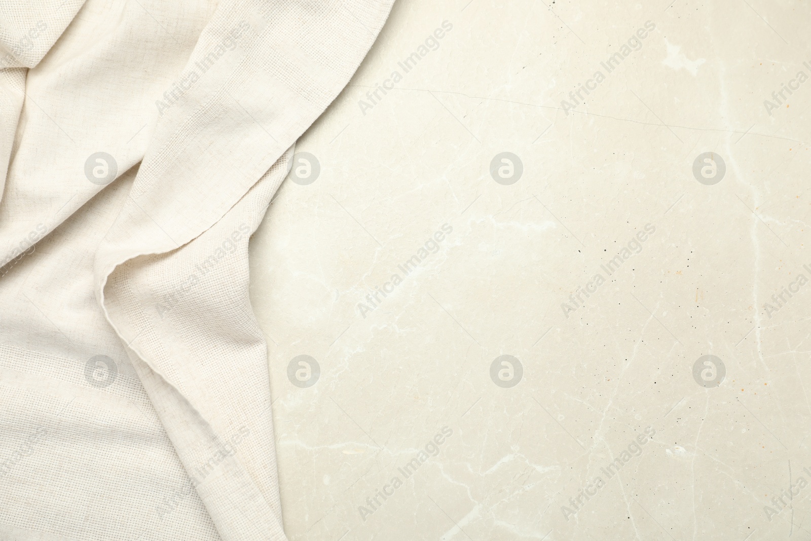 Photo of Beige tablecloth on light gray textured background, top view. Space for text