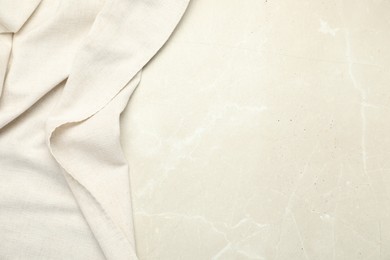 Photo of Beige tablecloth on light gray textured background, top view. Space for text