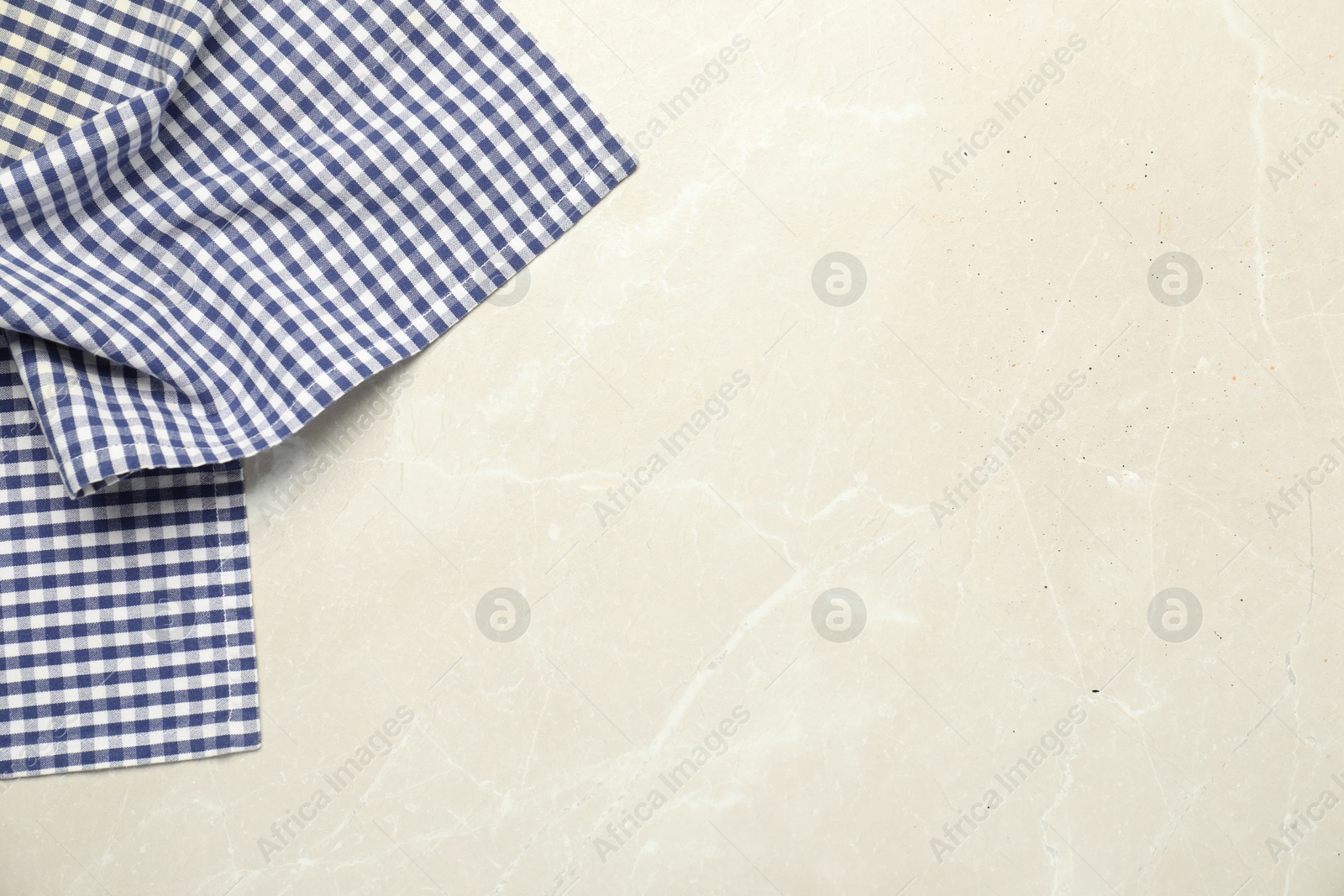 Photo of Blue checkered tablecloth on light gray textured background, top view. Space for text