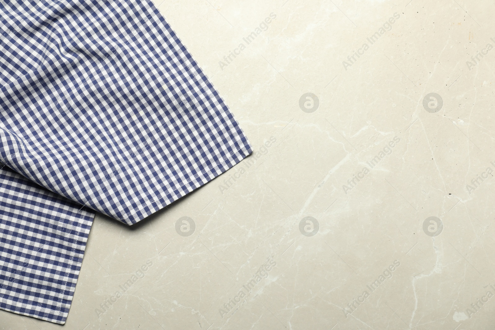 Photo of Blue checkered tablecloth on light gray textured background, top view. Space for text