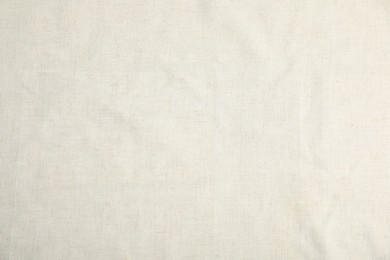 Photo of Texture of beige tablecloth as background, top view