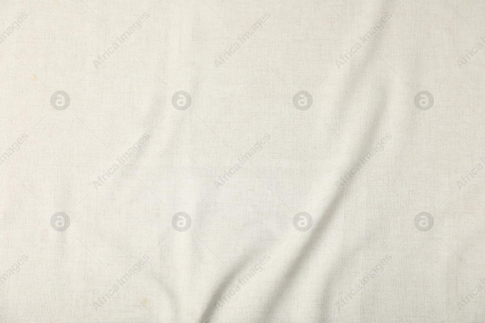 Photo of Texture of beige crumpled tablecloth as background, top view