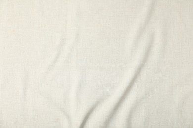 Photo of Texture of beige crumpled tablecloth as background, top view