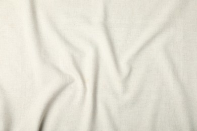 Photo of Texture of beige crumpled tablecloth as background, top view