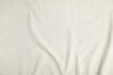 Photo of Texture of beige crumpled tablecloth as background, top view