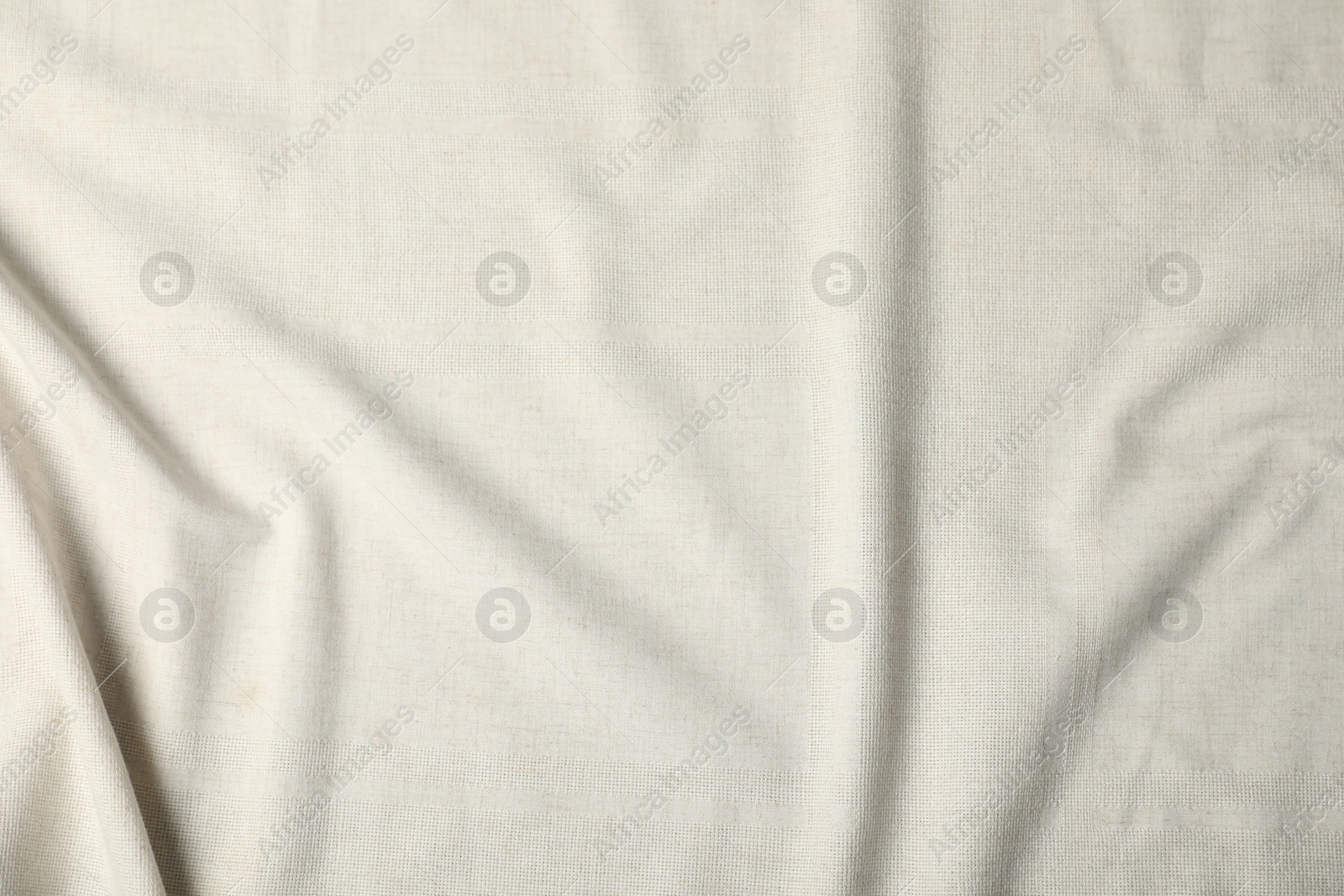 Photo of Texture of beige crumpled tablecloth as background, top view