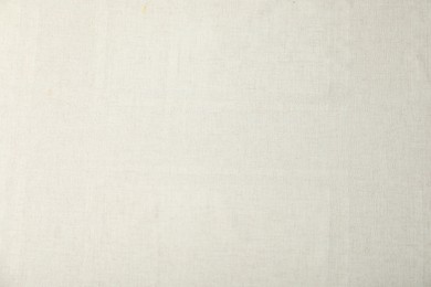 Photo of Texture of beige tablecloth as background, top view