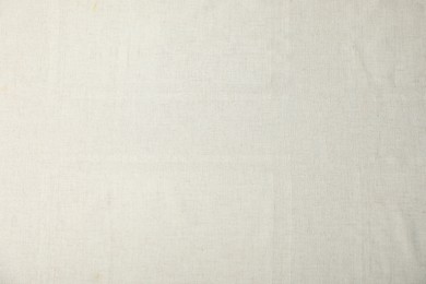 Photo of Texture of beige tablecloth as background, top view