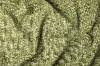 Photo of Texture of green crumpled tablecloth as background, top view