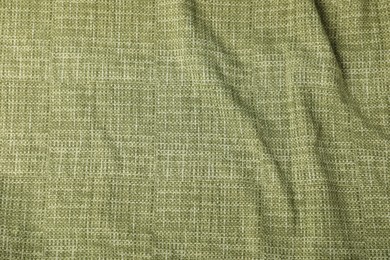 Photo of Texture of green crumpled tablecloth as background, top view