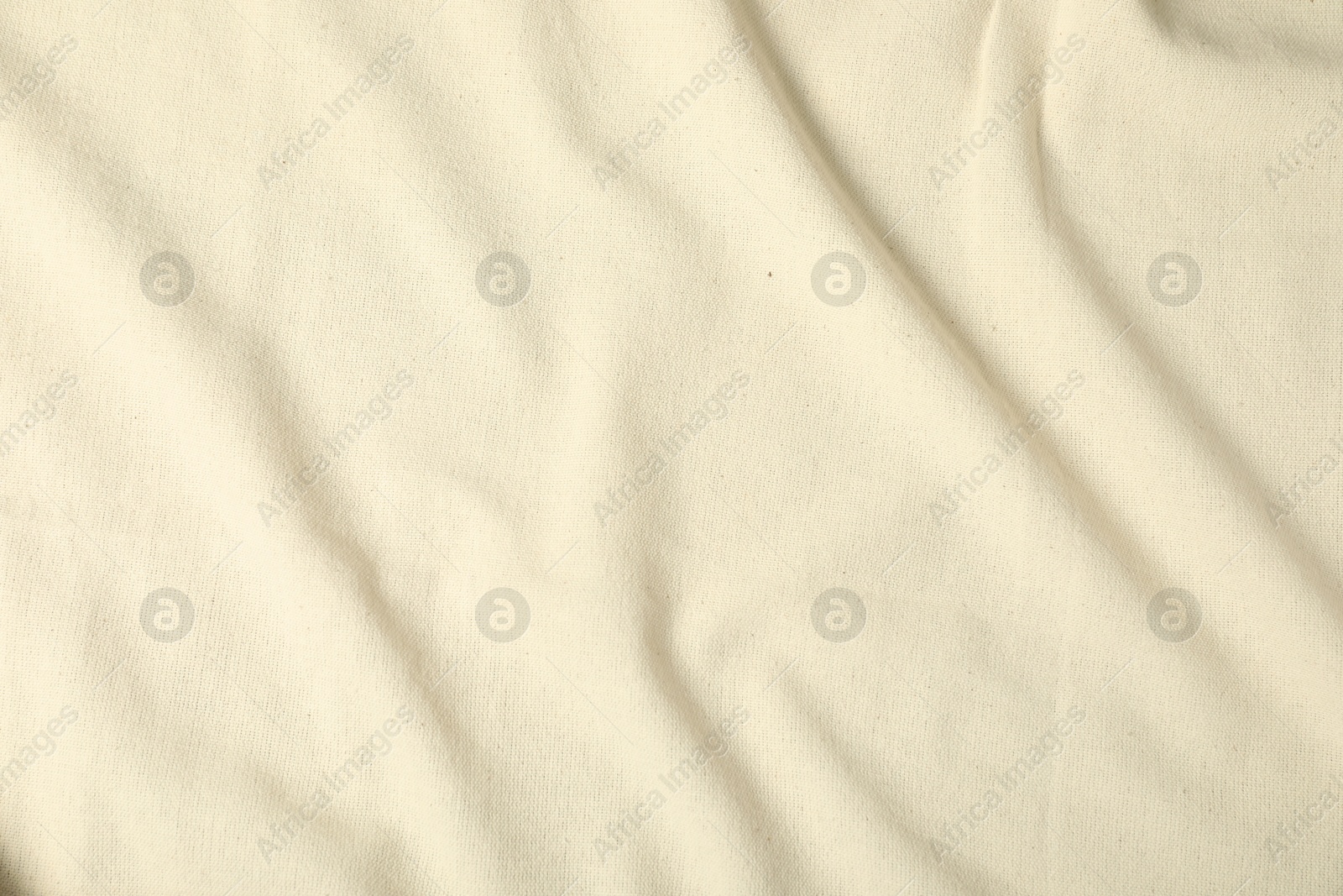 Photo of Texture of beige crumpled tablecloth as background, top view