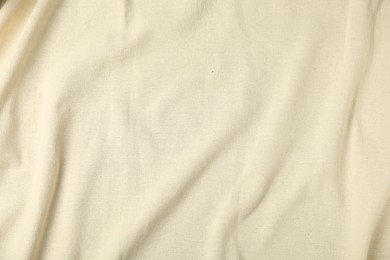 Photo of Texture of beige crumpled tablecloth as background, top view