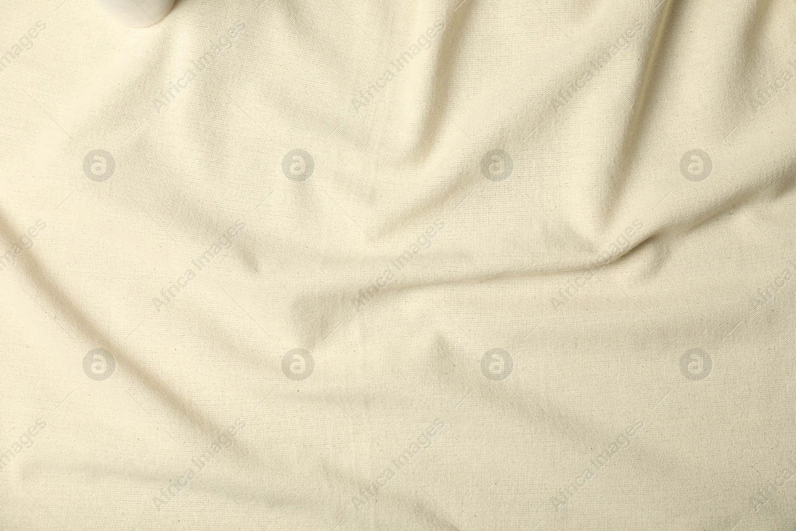 Photo of Texture of beige crumpled tablecloth as background, top view