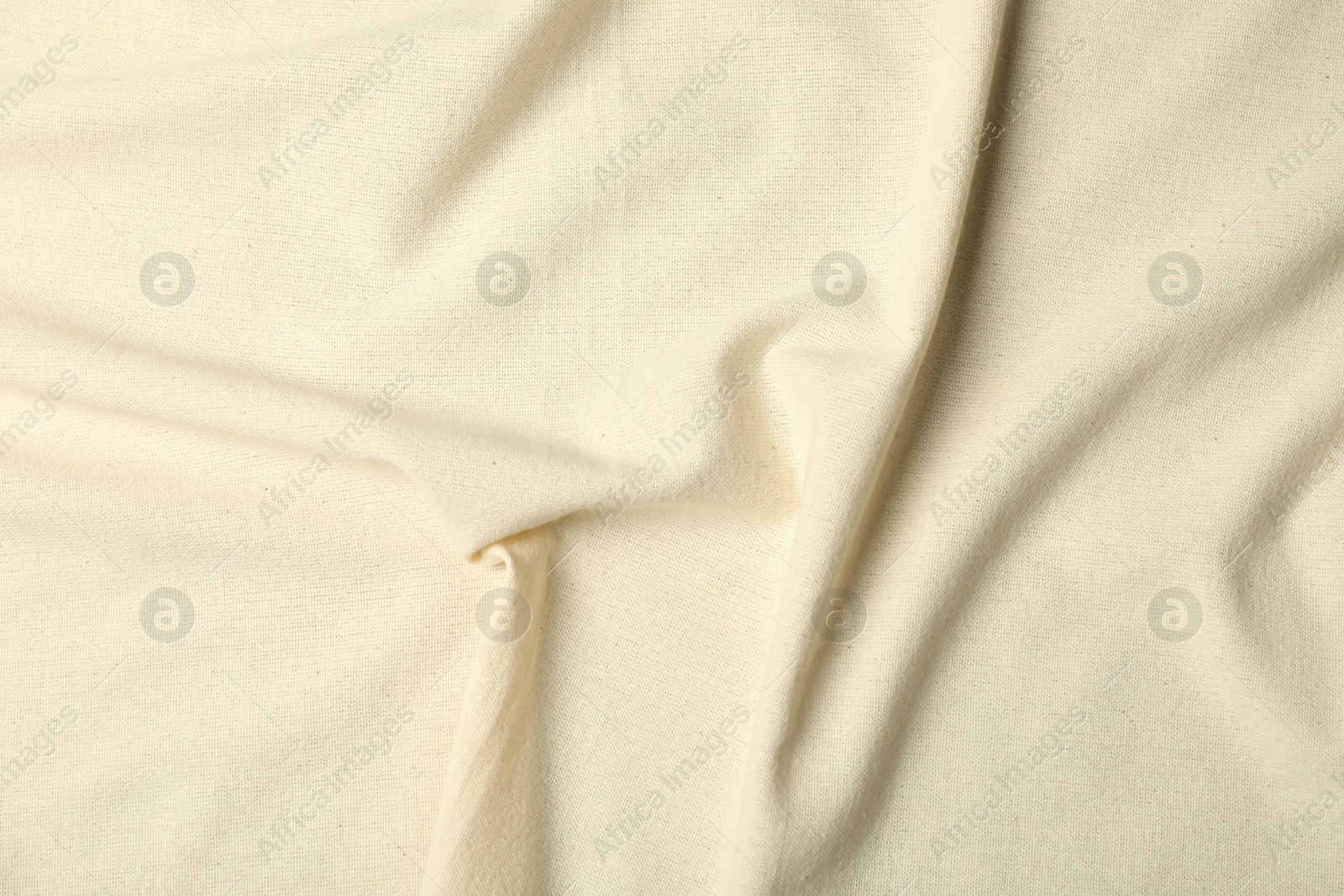 Photo of Texture of beige crumpled tablecloth as background, top view