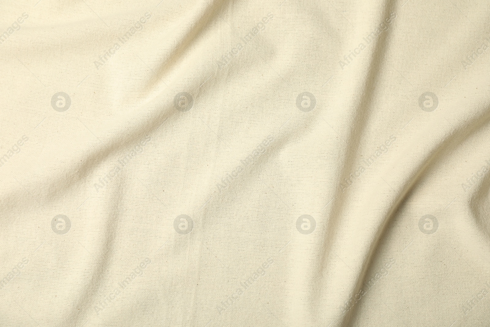 Photo of Texture of beige crumpled tablecloth as background, top view