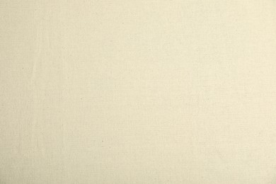 Photo of Texture of beige tablecloth as background, top view