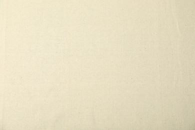 Photo of Texture of beige tablecloth as background, top view